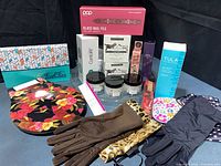 Full lot overview showing boxed skincare, cosmetics, gloves, board
