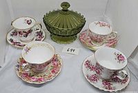 Group shot of four cup and saucer sets and green Fostoria candy dish
