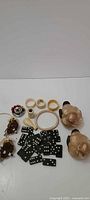 Assortment of bone items, dominoes, pottery birds and owl ornaments laid out