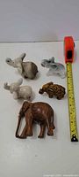 All five elephant figurines with measuring tape