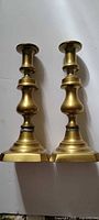 Front view of both brass candlesticks standing upright