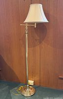 Full view of brass floor lamp with shade and cord
