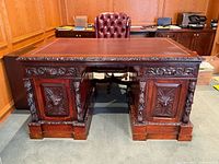 Front view showing carved cabinet side and leather top