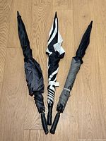 Three closed umbrellas showing canopy colours and handles