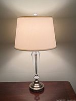 Full view of one lamp showing shade, acrylic column and metal base