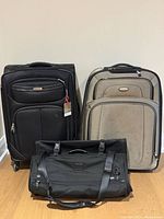 Group shot showing both Samsonite suitcases and Tumi garment bag