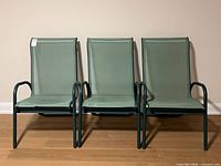 Front view of three green aluminum and mesh patio chairs