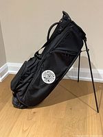 Left side view of black TaylorMade stand golf bag showing Summit GC logo, stand legs deployed