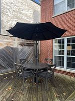Full patio set showing table, four chairs and umbrella