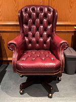 Front view of tufted leather chair showing overall style and condition
