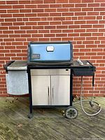 Front view of Weber Genesis Silver grill with hood closed and natural gas hose visible
