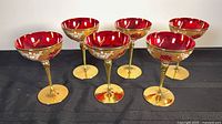 All six Murano ruby red champagne glasses displayed