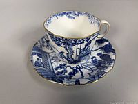 Side view of cup on saucer showing pattern and gold rim