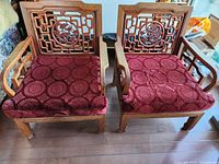 front view of both rosewood armchairs with red cushions