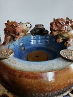 Overall fountain showing bowl, three animal figures, coin decorations