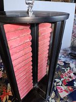 Side showing pink velvet ring rolls within black frame