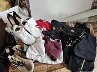 Group shot of all shoes, handbag and clothing laid out on bed