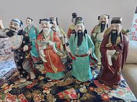 Group view of all eight porcelain Immortals on fabric