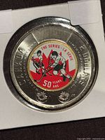 Reverse of 2022 Summit Series $2 coin in flip, colourized hockey design visible