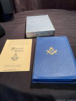 Bible, box, and pamphlet displayed on table