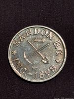 Obverse of token showing SANDON B.C. legend, crossed pick and shovel, ingot, date 1898