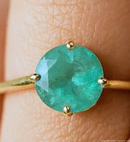 Close-up of emerald solitaire on gold band
