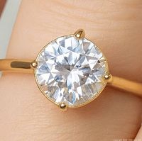 Front view of ring showing round brilliant lab diamond in four-prong setting on yellow gold band