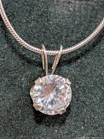 Close-up of round cubic zirconia pendant on silver snake chain