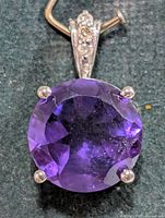 Front view of silver pendant showing round amethyst and prong setting