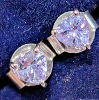 Close-up of both heart-cut tanzanite earrings in silver mounts