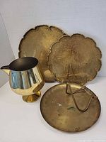 Group shot of two trays, pitcher, gong disc and stand