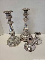 Two tall and two short silver-plated candlesticks