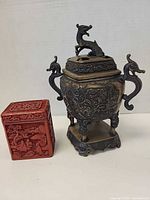 Both items side by side: red carved box and metal censer showing scale and overall design