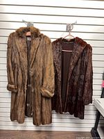 Both fur coats hanging side by side