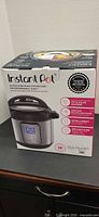 Front of sealed Instant Pot Duo Plus 60 box showing product image and branding