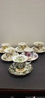 All six cup and saucer pairs arranged together showing variety of patterns