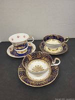 Three teacup and saucer sets, two matching Paragon, one Aynsley