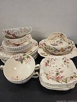 Overview of stacked dinnerware showing plates, bowls, handled soup bowls