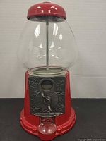 Front view showing coin mechanism, glass globe, red metal base and lid