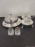 Full view of butter dish, caddy with cellars and spoons, and shakers