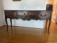 Full view of wood sideboard showing three drawers, cabriole legs
