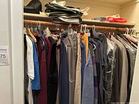 Full closet view showing quantity and variety of men’s garments on hangers