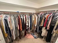 Full closet view with large quantity of hanging women’s garments on two rods