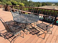 Round mesh-top patio table with four matching coil spring chairs