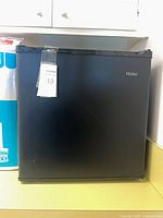 Front view of Haier black mini fridge