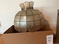 Front view of capiz shell globe shade in box