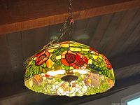 Side view of stained glass hanging lamp showing poppy motif, chain and canopy