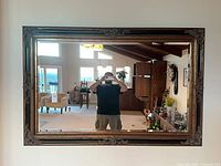 Front view of large ornate mirror mounted on wall