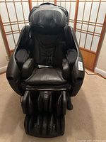 Front view of black Inada DreamWave massage chair showing seat, armrests, leg rest