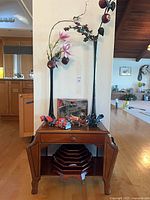 Front view of side table with vases, trays underneath, Transformers toys on top